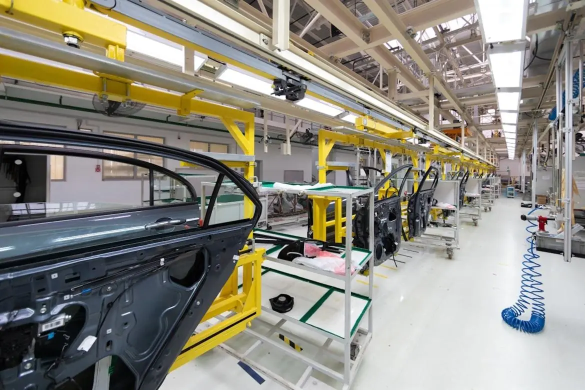 Automotive quality inspector examining car parts in a warehouse